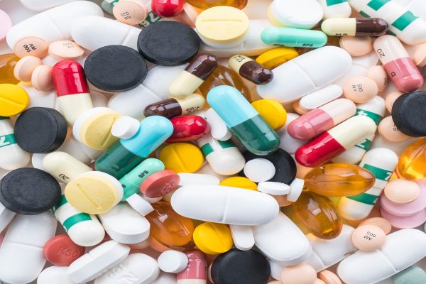 packings of pills and capsules of medicines on white background